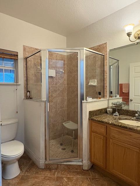 1895 Snapper Dr, Poinciana, FL 34759 - full bath with a shower stall, vanity, toilet, a textured ceiling, and tile patterned flooring