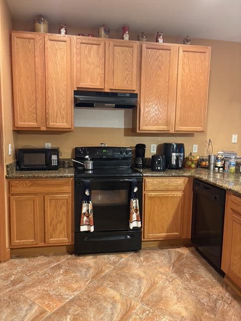 1895 Snapper Dr, Poinciana, FL 34759 - kitchen with black appliances, exhaust hood, and dark stone countertops