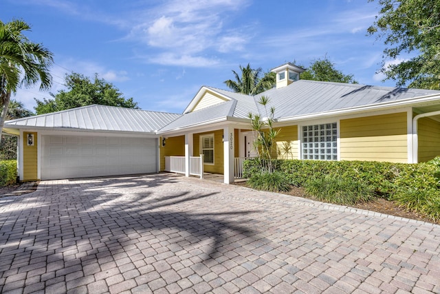 3020 SE St Lucie Blvd, Stuart, FL 34997 - ranch-style home featuring metal roof, a garage, decorative driveway, and covered porch