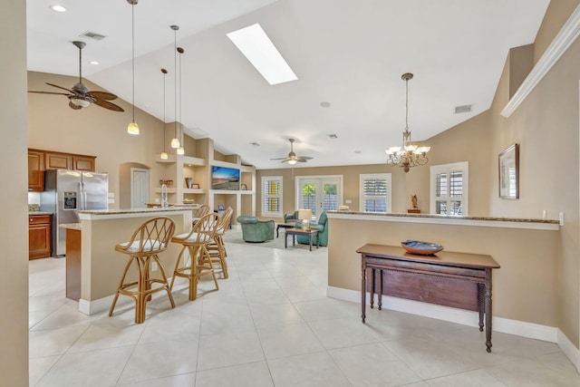 3020 SE St Lucie Blvd, Stuart, FL 34997 - kitchen with stainless steel refrigerator with ice dispenser, ceiling fan, brown cabinetry, a peninsula, and high vaulted ceiling