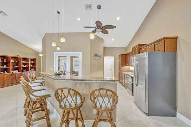 3020 SE St Lucie Blvd, Stuart, FL 34997 - kitchen featuring stainless steel appliances, ceiling fan, a breakfast bar, light stone countertops, and high vaulted ceiling