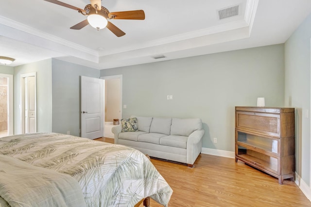 3020 SE St Lucie Blvd, Stuart, FL 34997 - bedroom with light wood-style flooring, a tray ceiling, baseboards, ceiling fan, and ornamental molding