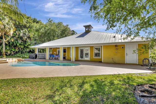 3020 SE St Lucie Blvd, Stuart, FL 34997 - back of property featuring a patio area, metal roof, a lawn, a pool with connected hot tub, and french doors