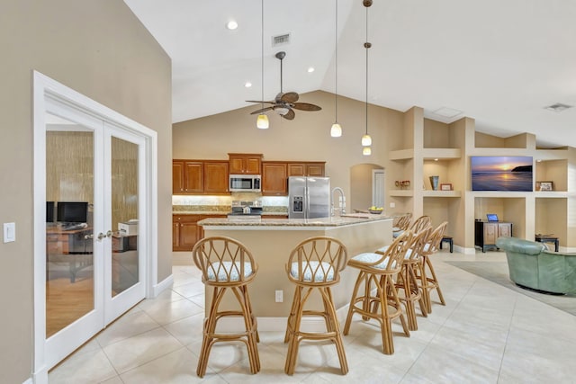 3020 SE St Lucie Blvd, Stuart, FL 34997 - kitchen featuring stainless steel appliances, french doors, brown cabinetry, ceiling fan, and a breakfast bar area
