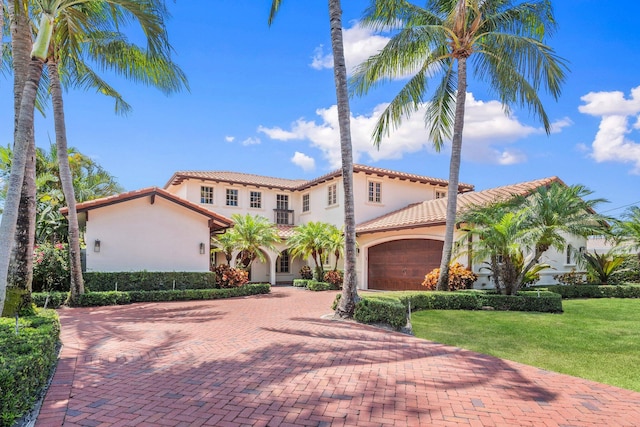 12891 Inshore Dr, Palm Beach Gardens, FL 33410 - mediterranean / spanish home featuring stucco siding, a tiled roof, a front lawn, and decorative driveway