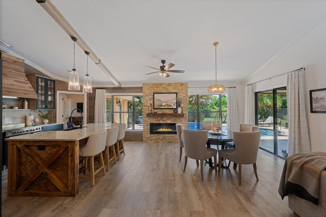 17315 Orange Blvd, Loxahatchee, FL 33470 - dining area with a fireplace, ceiling fan, light wood finished floors, ornamental molding, and a chandelier