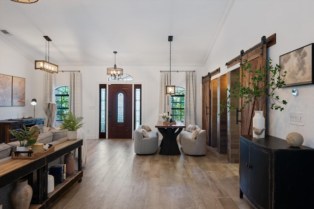 17315 Orange Blvd, Loxahatchee, FL 33470 - foyer entrance featuring healthy amount of natural light, wood finished floors, ornamental molding, and a barn door