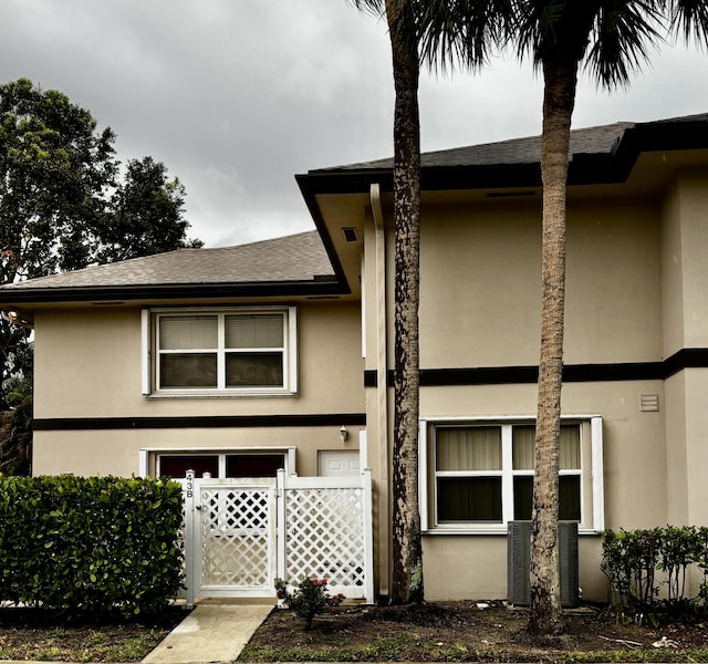 view of front of home with stucco siding and a shingled roof