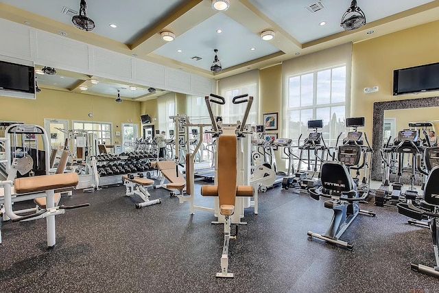 workout area featuring a towering ceiling and beamed ceiling
