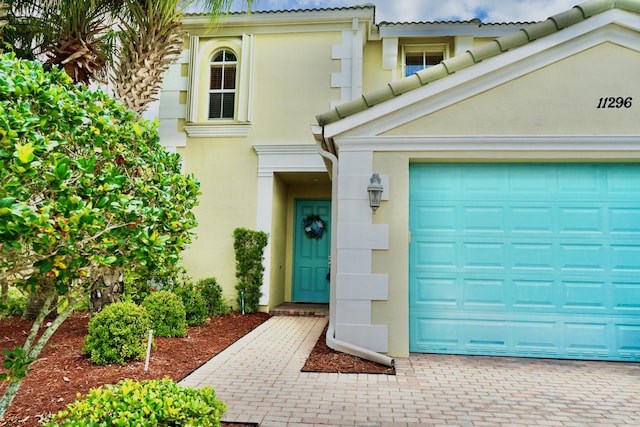 11296 SW Barton Way, Port Saint Lucie, FL 34987 - property entrance with stucco siding, a garage, and decorative driveway