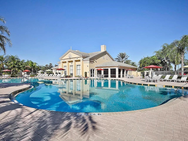 community pool with fence and a patio