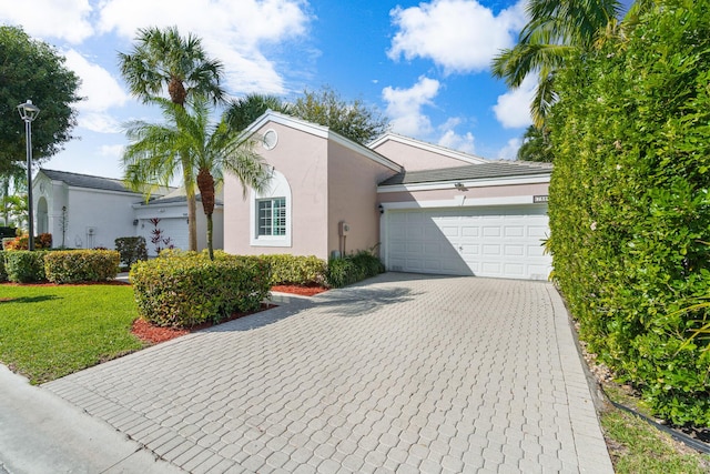 7884 Travlers Tree Dr, Boca Raton, FL 33433 - view of front facade with a garage, stucco siding, decorative driveway, and a front lawn