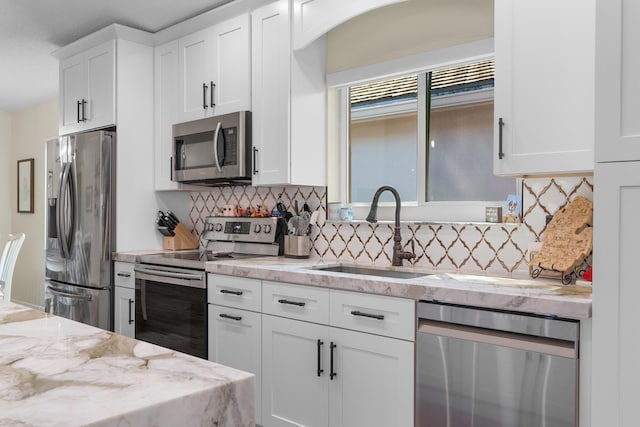 7884 Travlers Tree Dr, Boca Raton, FL 33433 - kitchen with appliances with stainless steel finishes, decorative backsplash, a sink, white cabinets, and light stone counters