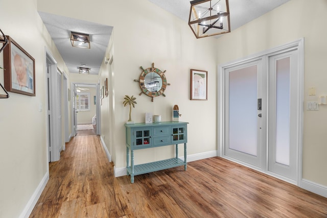 7884 Travlers Tree Dr, Boca Raton, FL 33433 - foyer entrance featuring wood finished floors, baseboards, and a chandelier