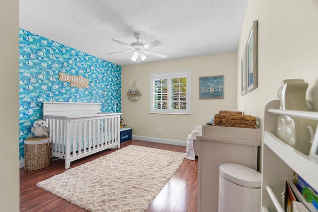 7884 Travlers Tree Dr, Boca Raton, FL 33433 - bedroom with baseboards, a textured ceiling, a nursery area, wood finished floors, and ceiling fan