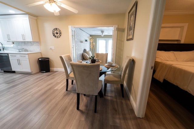 dining space with ceiling fan, light wood-style floors, baseboards, and ornamental molding