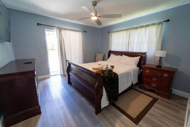 bedroom with wood finished floors, baseboards, and a ceiling fan