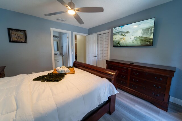 bedroom with wood finished floors, a closet, connected bathroom, and ceiling fan
