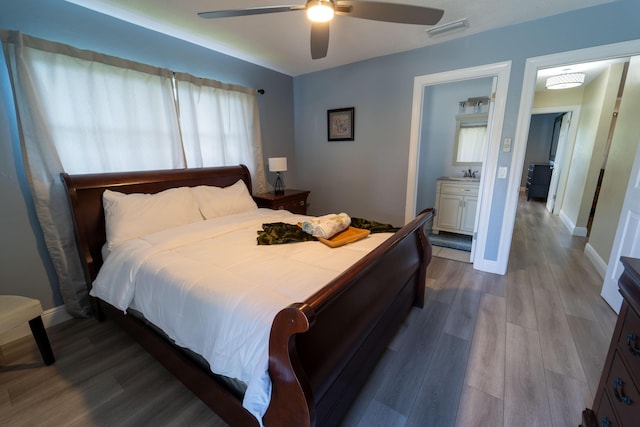 bedroom featuring wood finished floors, a sink, baseboards, and ceiling fan
