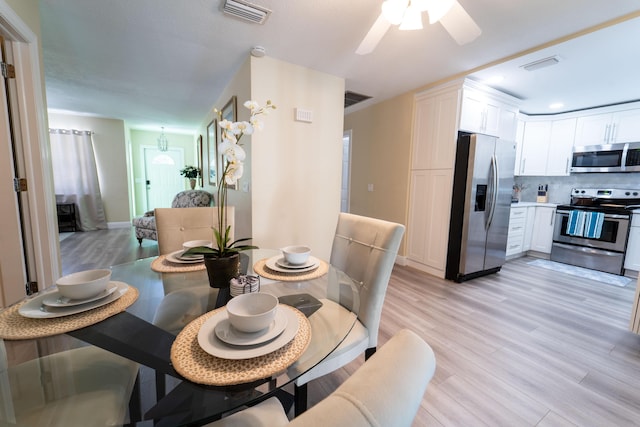 dining room featuring light wood-style flooring and a ceiling fan
