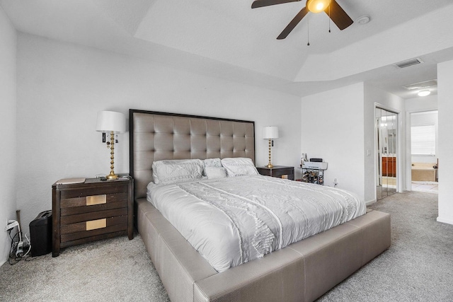 bedroom with light colored carpet, connected bathroom, and ceiling fan