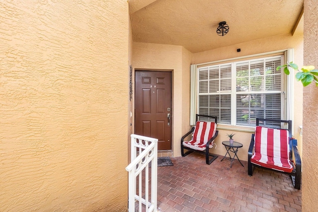 entrance to property with stucco siding and a porch