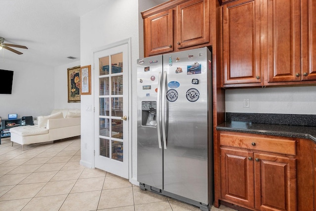 kitchen featuring stainless steel fridge, ceiling fan, open floor plan, light tile patterned flooring, and brown cabinetry
