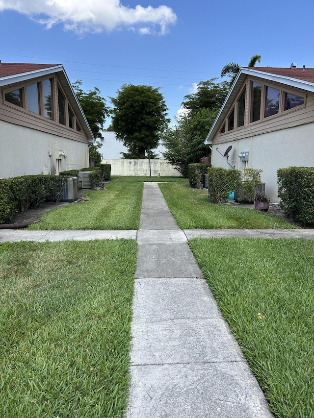 4393 Woodstock Dr Unit C, West Palm Beach, FL 33409 - view of grassy yard featuring central AC unit