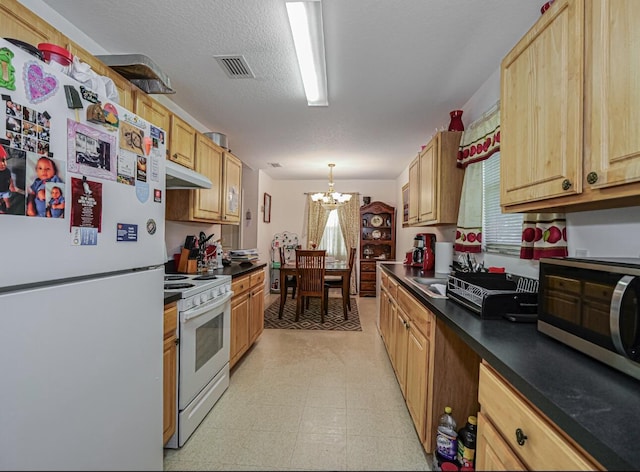 4257 36th Ct, Vero Beach, FL 32967 - kitchen featuring white appliances, a chandelier, dark countertops, light floors, and decorative light fixtures