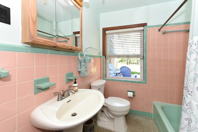 1116 NE Oceanview Cir, Jensen Beach, FL 34957 - bathroom with tile walls, a sink, toilet, shower / bath combination with curtain, and a wainscoted wall