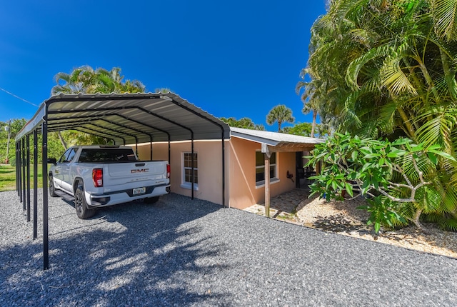 1116 NE Oceanview Cir, Jensen Beach, FL 34957 - view of parking featuring a detached carport and gravel driveway