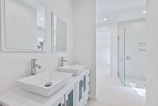 bathroom featuring a stall shower, recessed lighting, double vanity, and tile patterned floors