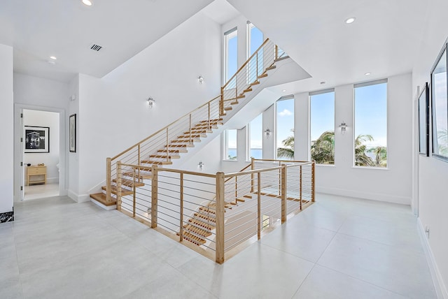 stairs featuring healthy amount of natural light, baseboards, and recessed lighting