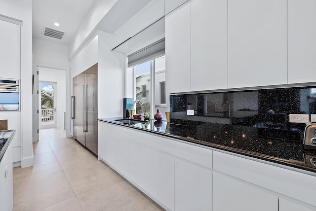 kitchen with a sink, white cabinetry, modern cabinets, and appliances with stainless steel finishes