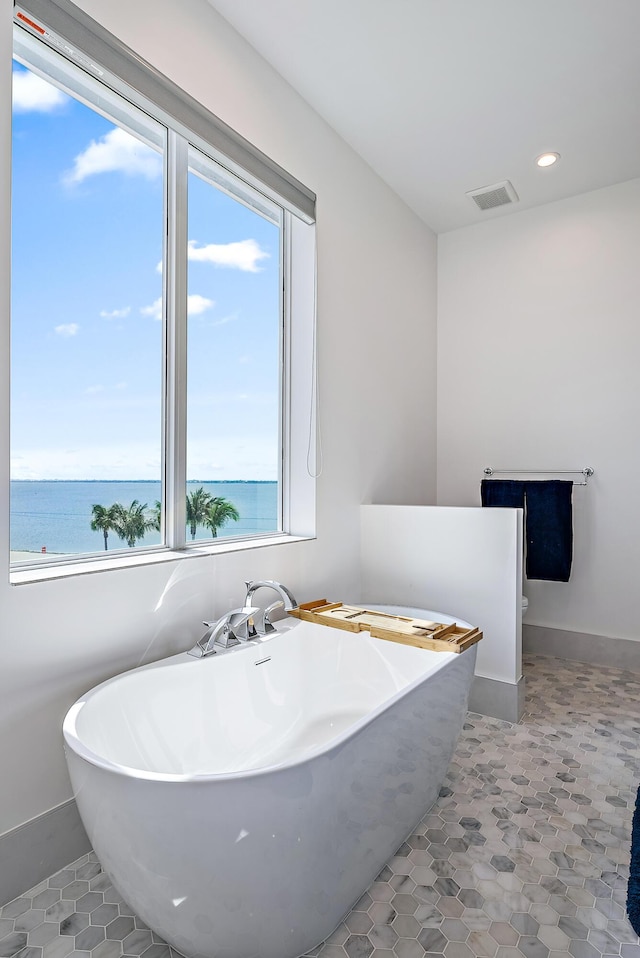 bathroom featuring a freestanding bath and recessed lighting