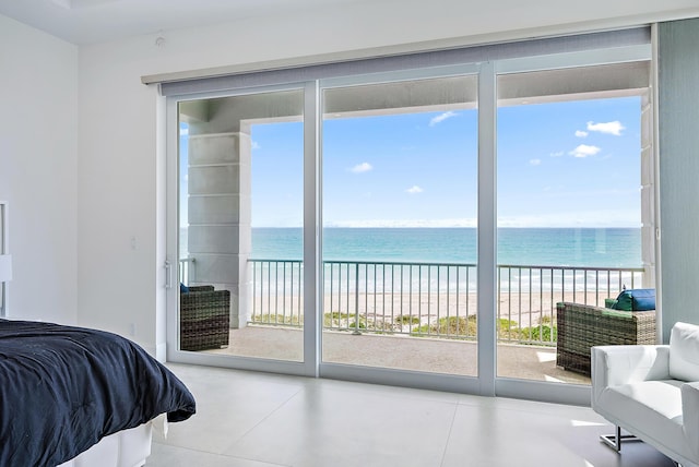 bedroom with access to exterior, multiple windows, view of water and beach, and tile patterned floors