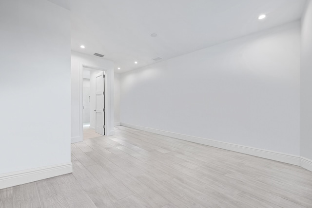 spare room with baseboards, recessed lighting, and light wood-style flooring
