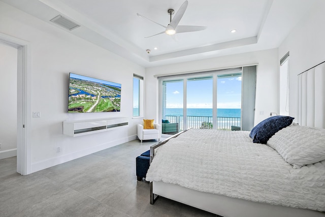 bedroom with access to outside, a raised ceiling, concrete floors, baseboards, and recessed lighting