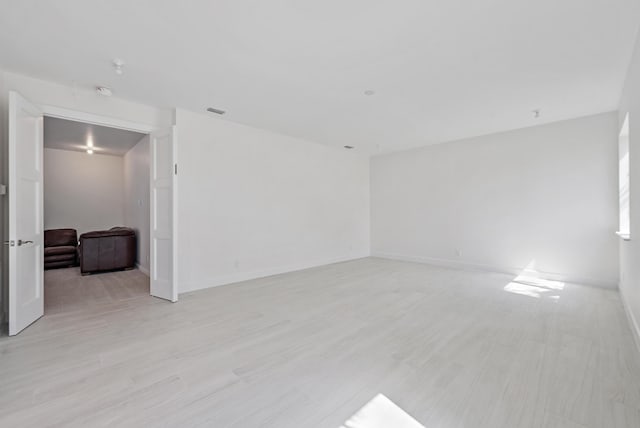empty room featuring light wood-type flooring and baseboards
