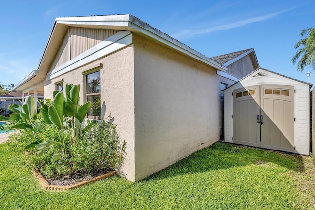 1181 Larch Way, Wellington, FL 33414 - view of side of home featuring a storage unit, a yard, an outbuilding, and stucco siding