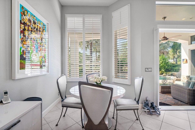 tiled dining room featuring baseboards and ceiling fan