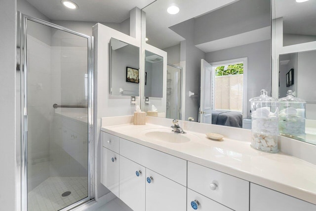 bathroom with a shower stall, ensuite bathroom, vanity, and recessed lighting