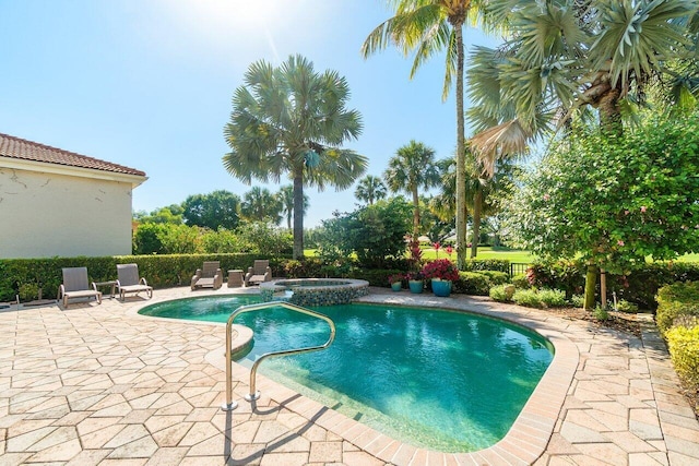 view of swimming pool featuring a patio and a pool with connected hot tub