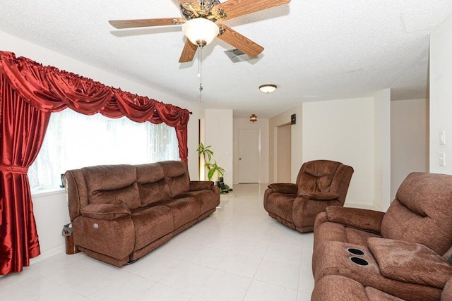 1117 SE Mendoza Ave, Port Saint Lucie, FL 34952 - living area with light tile patterned floors, a ceiling fan, and a textured ceiling