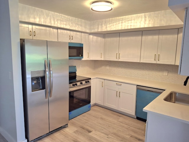 6515 Chasewood Dr Unit D, Jupiter, FL 33458 - kitchen with stainless steel appliances, light countertops, a sink, decorative backsplash, and light wood-style flooring