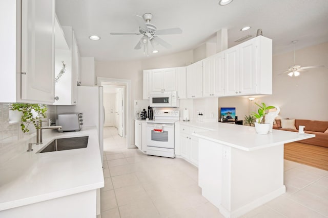 10853 SW Elsinore Dr, Port Saint Lucie, FL 34987 - kitchen featuring white appliances, ceiling fan, a peninsula, backsplash, and recessed lighting