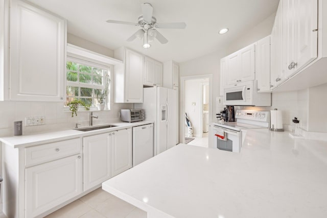 10853 SW Elsinore Dr, Port Saint Lucie, FL 34987 - kitchen featuring white appliances, a sink, a ceiling fan, tasteful backsplash, and light countertops