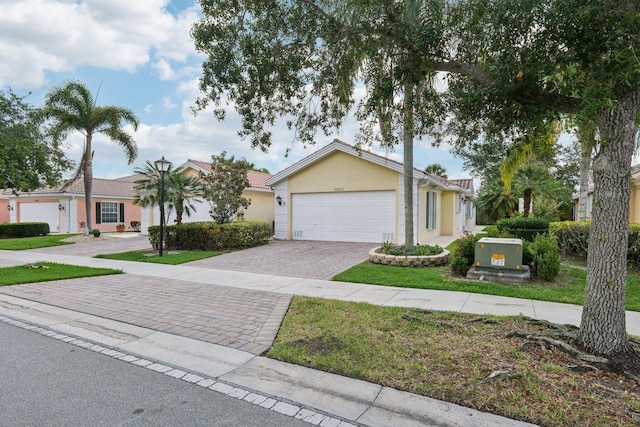 10853 SW Elsinore Dr, Port Saint Lucie, FL 34987 - view of front facade with a garage, decorative driveway, stucco siding, and a tile roof