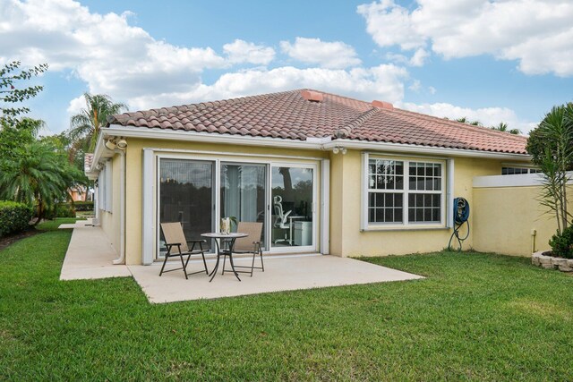10853 SW Elsinore Dr, Port Saint Lucie, FL 34987 - rear view of property featuring a patio, stucco siding, a lawn, and a tile roof