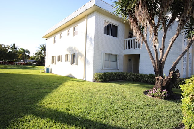 9842 Marina Blvd Unit 711, Boca Raton, FL 33428 - view of property exterior with brick siding, a lawn, and a balcony